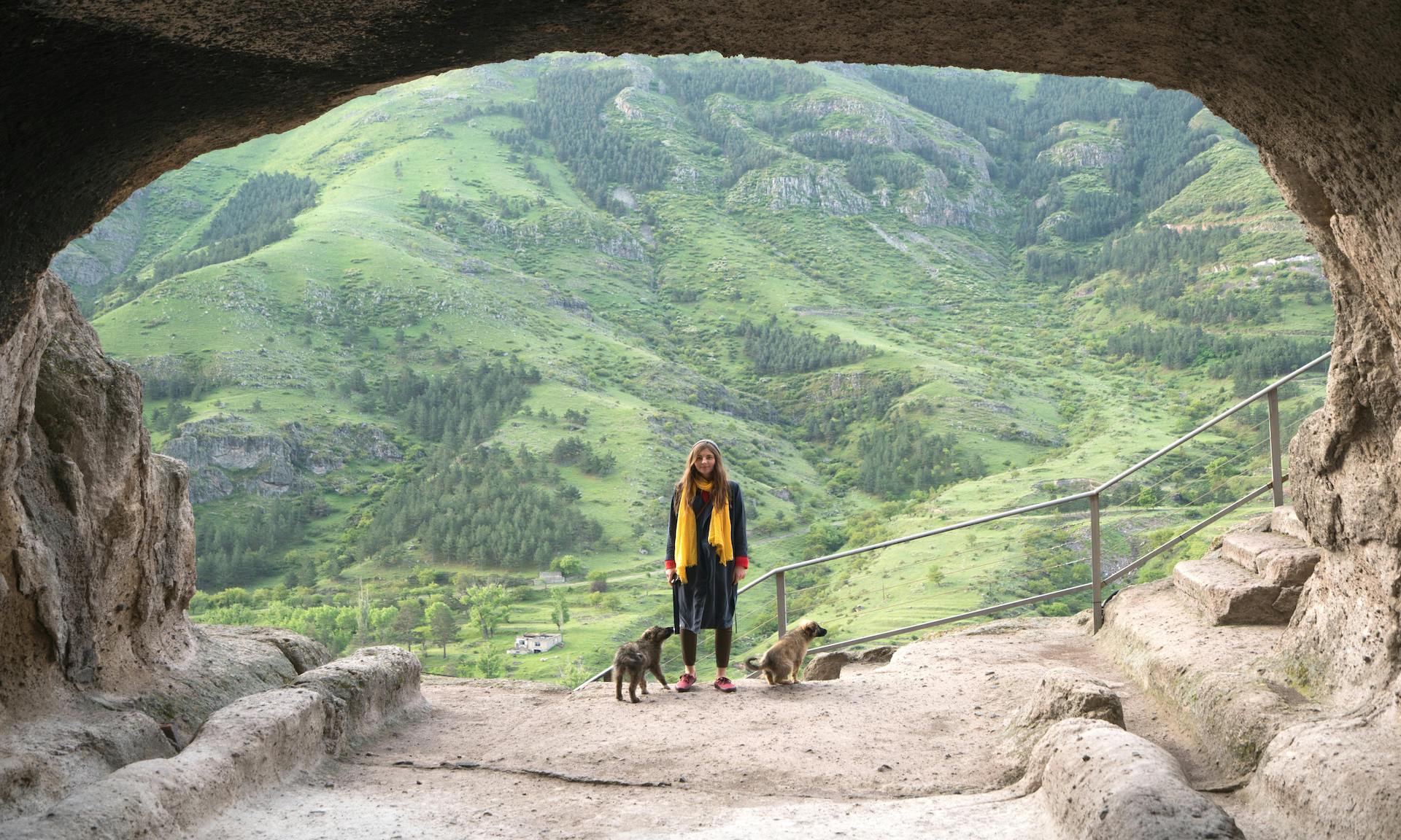 Person Standing In A Cave With Dogs